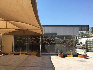 拉斯阿尔卡麦OYO Al Taj Rest House的前面有伞的建筑