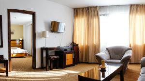 布加勒斯特HOTEL CRISS的酒店客房设有书桌和卧室。