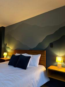 巴尼奥斯Hotel Agave Baños的卧室配有一张墙壁上漆有山脉的床铺。