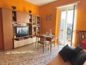科莱尼奥APPARTAMENTO COMFORT e SERVIZI - Casa Gramsci的客厅配有桌子和电视