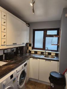 普拉姆斯特德Tuscawilla 2的厨房配有水槽和洗衣机