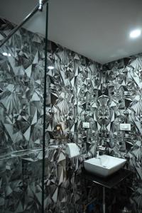 贾姆谢德布尔Hotel Trax International的一间带水槽和瓷砖墙的浴室