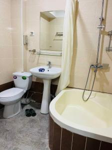 杜尚别ObodHotel的浴室配有盥洗盆、卫生间和浴缸。