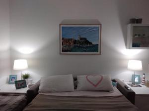 莱里奇Appartamento Emozione Mare Blu San Terenzo的一间卧室配有一张带粉红色心枕的床