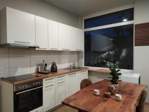 斯图加特Andris Apartments的厨房配有白色橱柜和木桌