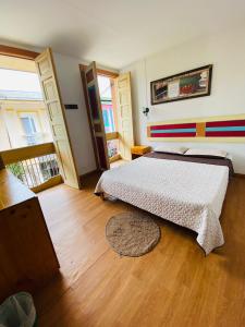 圣罗莎德卡瓦尔Hostal Don Jose的一间卧室配有一张床,铺有木地板
