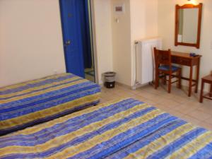 费索斯Katia Hotel的一间卧室配有一张床、一张桌子和一把椅子