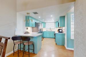 土桑Camino los Mochis的厨房配有蓝色橱柜和2个酒吧凳