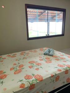 阿拉瓜伊纳Refúgio Aconchegante e Espaçoso的一张带花卉床罩的床,带窗户