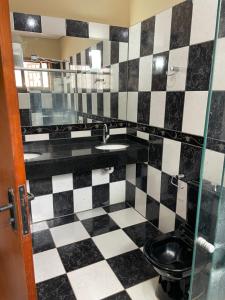 阿拉瓜伊纳Refúgio Aconchegante e Espaçoso的浴室铺有黑白格子地板。