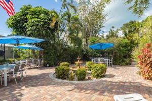 基韦斯特Bermuda Suite by Brightwild的一个带桌椅和蓝伞的庭院