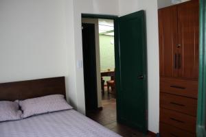 杜伊塔马Casa Mostaza Pueblito Boyacense的一间卧室配有一张床和一个绿色衣柜