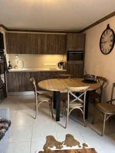 普拉波特尔les 7 laux immobilier chalet E的厨房配有桌椅和时钟