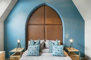 纽基Towan House的一间卧室配有一张带蓝色墙壁的大床