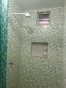 萨利诺波利斯Apartamentos no Farol Velho的一间带瓷砖淋浴和窗户的浴室