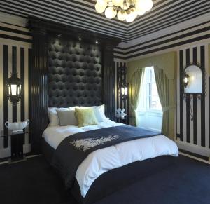 斯内蒂瑟姆Carrington House的一间卧室配有一张大床和大床头板