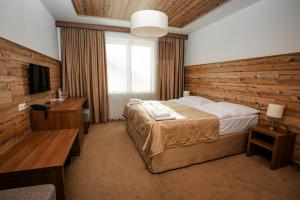 多纳瓦利Šport Hotel *** Donovaly的一间卧室设有一张床和木墙