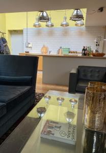 伦敦Victoria Park Apartment的客厅配有玻璃桌和酒杯