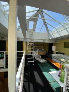 伦敦Victoria Park Apartment的带玻璃屋顶的客房,设有楼梯和沙发