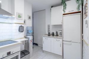 马贝拉Home Away From Home Marbella的厨房配有白色橱柜和冰箱。
