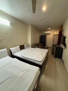 贾姆穆Hotel Himgiri的一间客房配有两张床和一张沙发