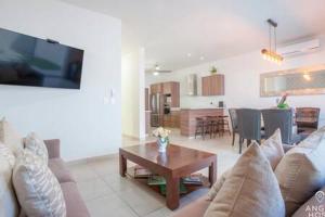 拉巴斯Spacious home with private yard and community pool的带沙发和桌子的客厅以及厨房。