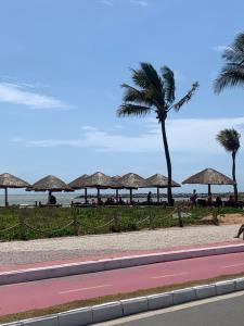 塞拉JacaraipeTop的一片带草伞和棕榈树的海滩