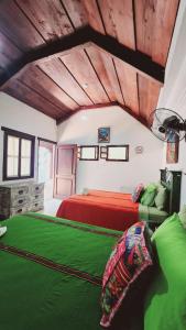 危地马拉安地瓜MAGNOLIAS的一间卧室配有红色的床和绿色床单