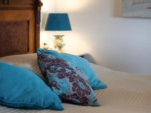 阿本贝格阿本贝格酒店的一张带两个蓝色枕头和一盏灯的床