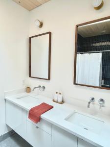 Marion BridgeModern waterfront cottage +hot tub的白色的浴室设有两个盥洗盆和镜子