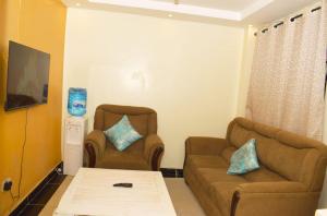 ThikaFully furnished One bedroom bnb in Thika Town.的客厅配有两把椅子和一张沙发