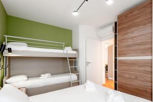 米兰StayEasy Argelati40 - Penthouse with 2 bedrooms, 2 bathrooms and terrace - Navigli的一间卧室设有两张双层床和绿色的墙壁