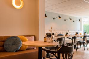 霍勒姆Hotel-Brasserie De Walvisvaarder的餐厅设有桌椅和沙发。