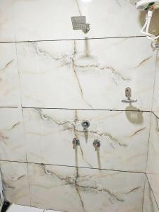 乌贾因Hotel ST INN的白色大理石浴室设有水槽和水龙头
