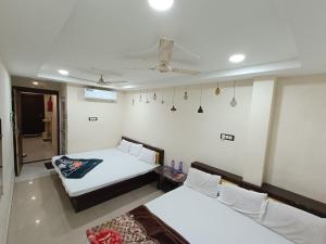 乌贾因Hotel ST INN的客房设有两张床和吊扇。