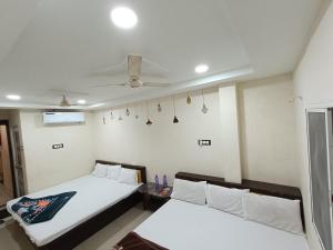 乌贾因Hotel ST INN的一间卧室配有两张床和吊扇