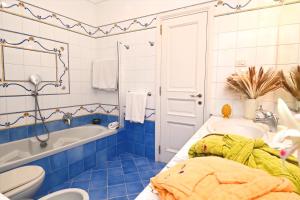 卡普里Villa Maiora的蓝色的浴室设有浴缸和水槽