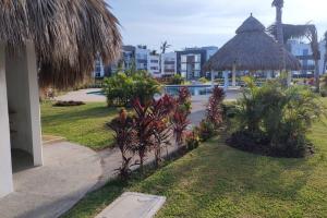 阿卡普尔科Depto. con club de Playa的享有带游泳池和大楼的度假村景色