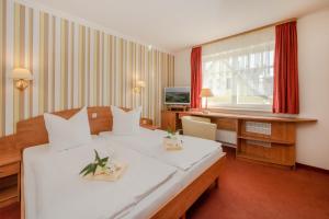 Usedom TownGasthaus & Pension Natzke的酒店客房配有两张床和一张书桌