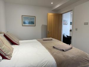 本布里奇The Pilot Boat Inn, Isle of Wight的一间卧室配有一张大床和两条毛巾