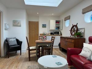 本布里奇The Pilot Boat Inn, Isle of Wight的客厅配有红色的沙发和桌子