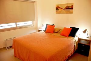 布宜诺斯艾利斯Departamento en Flores, Ciudad de Buenos Aires的一间卧室配有带橙色枕头的大型橙色床