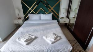 迪拜Granada Apartments Elite Residence的一间卧室配有一张床,上面有两条毛巾