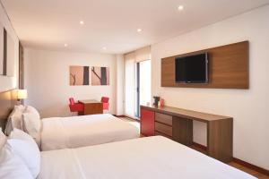 波哥大84 DC Bogotá的酒店客房设有两张床和一台平面电视。