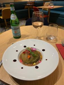 卡尔卡松Kyriad Carcassonne - Aéroport的桌上的一盘食物和一瓶葡萄酒