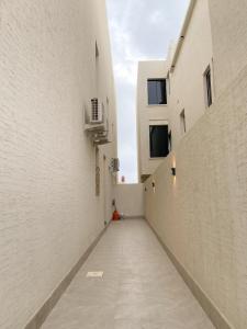 艾卜哈نزل الراشد الفاخرة luxury的一条在两座白色建筑之间的小巷,有走廊