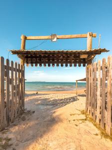 伊塔帕里卡Itaparica praia hotel的海滩上的木门与大海