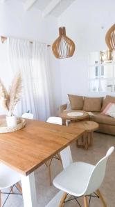 科尔多瓦Casa Deco con Pileta, Asador y Cochera的客厅配有木桌和白色椅子