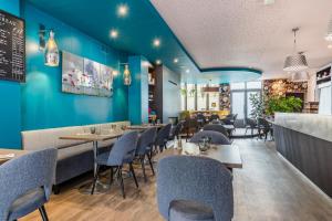 雷恩乐维多利亚餐厅酒店的餐厅拥有蓝色的墙壁和桌椅