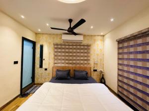 印多尔Home Escape Luxe 2BHK Penthouse Near LIG Square的一间卧室配有一张带吊扇的床